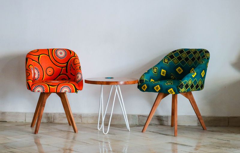 Silla con estructura metálica delgada junto a una mesa de madera